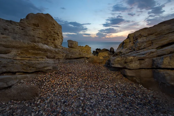 俄罗斯 Dagestan 在靠近Makhachkala城堤的里海布满贝壳的岩石海岸黎明时分 — 图库照片