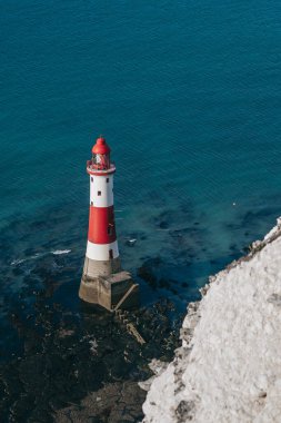 Bir Beachy Head Deniz feneri ve tebeşir kayalıklarının renkli gündoğumunda İngiltere 'de, Eastbourne yakınlarında alçak gelgitle çekilmiş manzara fotoğrafı.