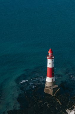 Bir Beachy Head Deniz feneri ve tebeşir kayalıklarının renkli gündoğumunda İngiltere 'de, Eastbourne yakınlarında alçak gelgitle çekilmiş manzara fotoğrafı.