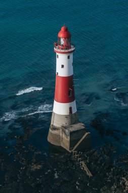 Bir Beachy Head Deniz feneri ve tebeşir kayalıklarının renkli gündoğumunda İngiltere 'de, Eastbourne yakınlarında alçak gelgitle çekilmiş manzara fotoğrafı.