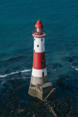 Bir Beachy Head Deniz feneri ve tebeşir kayalıklarının renkli gündoğumunda İngiltere 'de, Eastbourne yakınlarında alçak gelgitle çekilmiş manzara fotoğrafı.