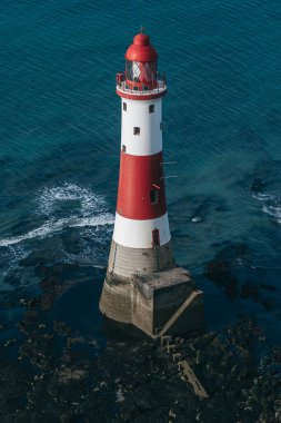 Bir Beachy Head Deniz feneri ve tebeşir kayalıklarının renkli gündoğumunda İngiltere 'de, Eastbourne yakınlarında alçak gelgitle çekilmiş manzara fotoğrafı.