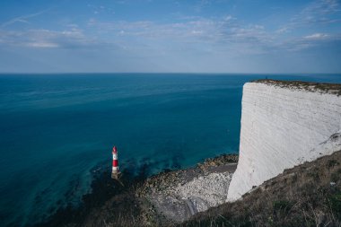 Bir Beachy Head Deniz feneri ve tebeşir kayalıklarının renkli gündoğumunda İngiltere 'de, Eastbourne yakınlarında alçak gelgitle çekilmiş manzara fotoğrafı.