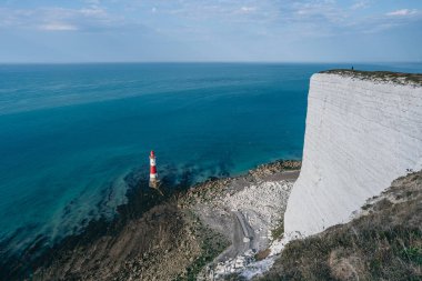 Bir Beachy Head Deniz feneri ve tebeşir kayalıklarının renkli gündoğumunda İngiltere 'de, Eastbourne yakınlarında alçak gelgitle çekilmiş manzara fotoğrafı.