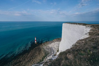 Bir Beachy Head Deniz feneri ve tebeşir kayalıklarının renkli gündoğumunda İngiltere 'de, Eastbourne yakınlarında alçak gelgitle çekilmiş manzara fotoğrafı.