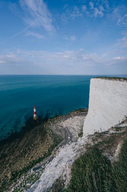 Bir Beachy Head Deniz feneri ve tebeşir kayalıklarının renkli gündoğumunda İngiltere 'de, Eastbourne yakınlarında alçak gelgitle çekilmiş manzara fotoğrafı.