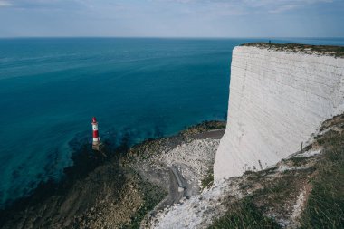 Bir Beachy Head Deniz feneri ve tebeşir kayalıklarının renkli gündoğumunda İngiltere 'de, Eastbourne yakınlarında alçak gelgitle çekilmiş manzara fotoğrafı.
