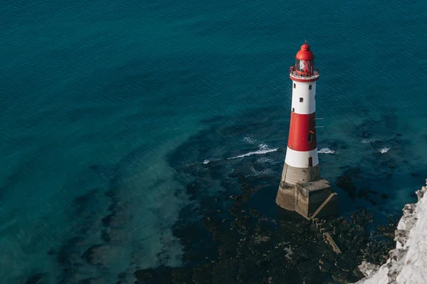 Bir Beachy Head Deniz feneri ve tebeşir kayalıklarının renkli gündoğumunda İngiltere 'de, Eastbourne yakınlarında alçak gelgitle çekilmiş manzara fotoğrafı.