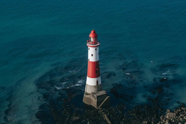 Bir Beachy Head Deniz feneri ve tebeşir kayalıklarının renkli gündoğumunda İngiltere 'de, Eastbourne yakınlarında alçak gelgitle çekilmiş manzara fotoğrafı.