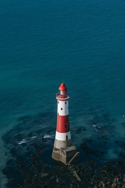 Bir Beachy Head Deniz feneri ve tebeşir kayalıklarının renkli gündoğumunda İngiltere 'de, Eastbourne yakınlarında alçak gelgitle çekilmiş manzara fotoğrafı.