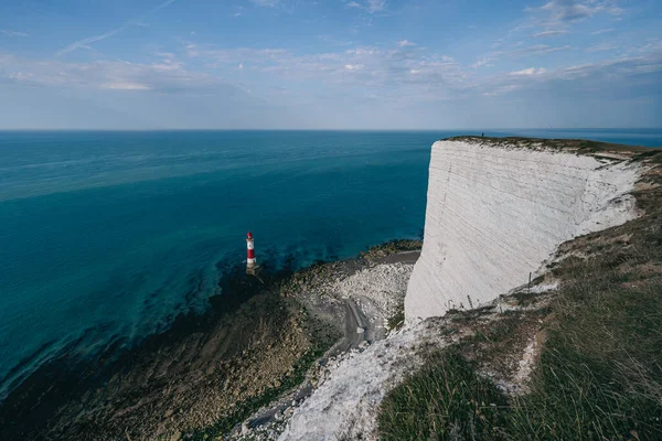 Bir Beachy Head Deniz feneri ve tebeşir kayalıklarının renkli gündoğumunda İngiltere 'de, Eastbourne yakınlarında alçak gelgitle çekilmiş manzara fotoğrafı.