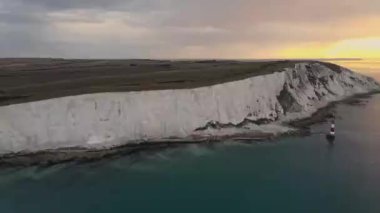 Bir Beachy Head Deniz feneri ve tebeşir kayalıklarının Eastbourne yakınlarında, İngiltere 'de alçak gelgitle birlikte renkli gündoğumunda çekilmiş peyzaj hava aracı görüntüleri.