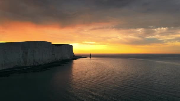 英国伊斯特伯恩附近的一座海滩头灯塔和粉笔悬崖在多彩的日出低潮中的景观空中无人驾驶视频 — 图库视频影像