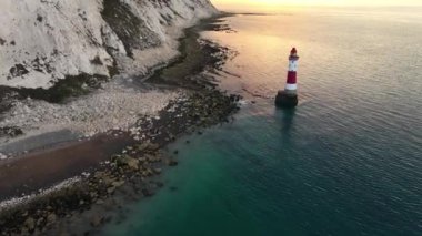 Bir Beachy Head Deniz feneri ve tebeşir kayalıklarının Eastbourne yakınlarında, İngiltere 'de alçak gelgitle birlikte renkli gündoğumunda çekilmiş peyzaj hava aracı görüntüleri.