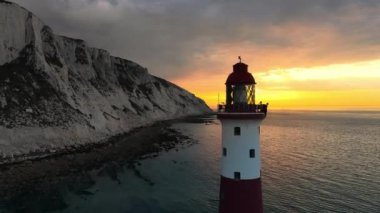 Bir Beachy Head Deniz feneri ve tebeşir kayalıklarının Eastbourne yakınlarında, İngiltere 'de alçak gelgitle birlikte renkli gündoğumunda çekilmiş peyzaj hava aracı görüntüleri.