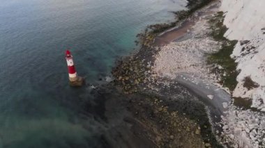 Bir Beachy Head Deniz feneri ve tebeşir kayalıklarının Eastbourne yakınlarında, İngiltere 'de alçak gelgitle birlikte renkli gündoğumunda çekilmiş peyzaj hava aracı görüntüleri.
