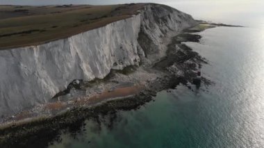 Bir Beachy Head Deniz feneri ve tebeşir kayalıklarının Eastbourne yakınlarında, İngiltere 'de alçak gelgitle birlikte renkli gündoğumunda çekilmiş peyzaj hava aracı görüntüleri.