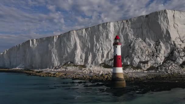 ビーチヘッド灯台とチョーク崖の風景空中ドローン映像英国の低潮位でカラフルな日の出 イーストボーンの近く — ストック動画