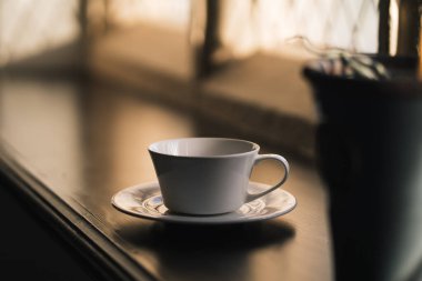 Güneşli bir sabah penceresinde boş kahve fincanı