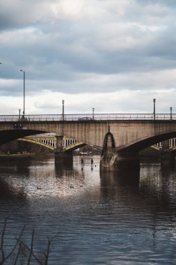 Richmond, Londra 124; İngiltere - 2021.03.19: Güneşli bir akşamda Twickenham Köprüsü 'nün altındaki Stand Up Paddle tahtalarında iki adam