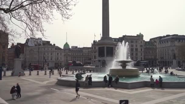 People hanging out at the Trafalgar Square fountains on warm sunny Spring day during Coronavirus Lockdown — Stock Video
