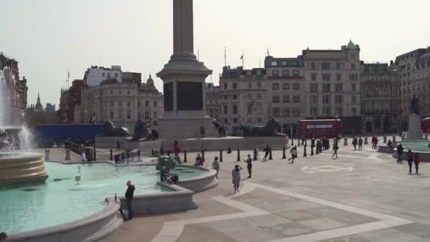 Lidé poflakující se na Trafalgar Square fontány na teplém slunném jarním dni během Coronavirus Lockdown — Stock video