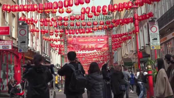 Люди в масках, идущие в Чайнатаун в Лондоне во время пандемии Коронавируса — стоковое видео