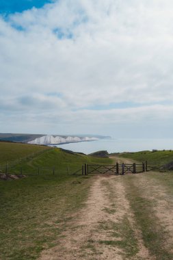 Seaford, Doğu Sussex (124; İngiltere - 2021.04.04): Chalk Cliffs yürüyüşünün tepesinden bulutlu bir sabahta Seaford Head Nature Reserve View. Yedi Kız Kardeş, Güney İngiltere