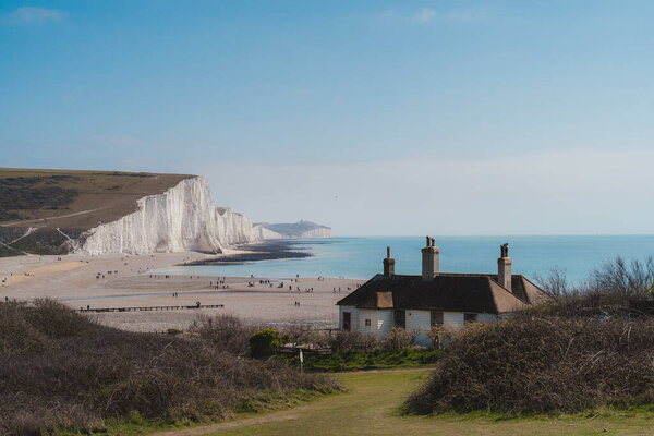 East Sussex presidentUK - 2021.04.04: Tiny House at the edge of the Chalk Cliffs at Seaford Head Nature Reserve, Cuckmere Haven beach. Семь сестёр на юге Англии
