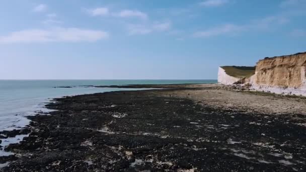 Vista aérea de las personas que caminan a la playa frente al mar de Cuckmere Haven durante la marea baja en la Reserva Natural de Seaford Head — Vídeos de Stock