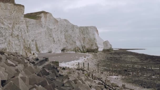 Seaford, East Sussex | UK. Křídové skalní útesy na pobřeží Sussexu s oblázkovou pláží a mořem za oblačného rána. Sedm sester. Anglie — Stock video