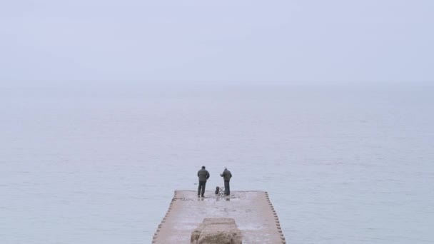 Männer angeln frühmorgens am Strand der Seven Sisters West — Stockvideo