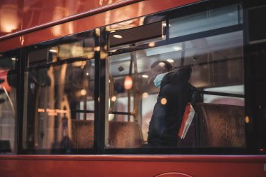 Soho, Londra -124; İngiltere - 2021.04.16: Siyah adam çift katlı otobüste oturuyor.