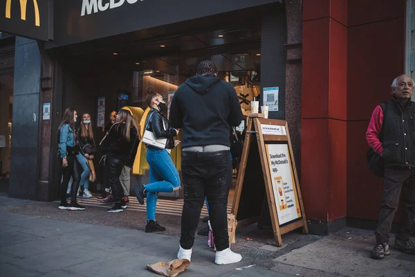 Soho, Londra the 124; İngiltere - 2021.04.16: Sarkık pantolonlu adam McDonald 's' ın önünde duruyor