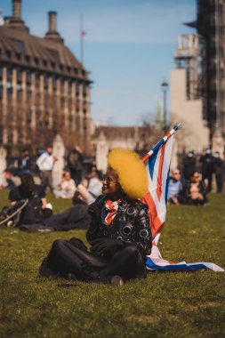 Westminster, Londra 124; İngiltere - 2021.04.17: Parlamento Meydanı 'ndaki Kill the Bill protestosunda Union Jack bayrağını sallayan güzel kişi