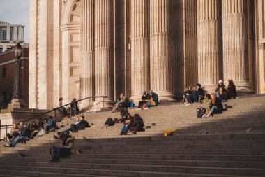 İngiltere - 2021.04.17: İnsanlar sıcak bir bahar gününde St. Pauls katedralinin merdivenlerinde güneşin tadını çıkarıyorlar