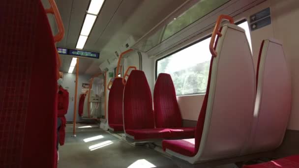 Téměř prázdný interiér vlaku South Western Railway s červenými sedadly a špinavými okny — Stock video