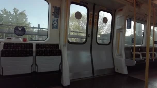 Treno vuoto della District Line che attraversa la West London nella soleggiata mattinata — Video Stock