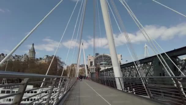 Le persone che camminano lungo il Golden Jubilee Bridge la soleggiata domenica mattina — Video Stock