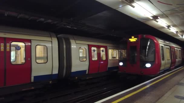 Estação de metrô subterrânea Embankment vazio com trem chegando à plataforma após a facilidade Coronavirus Lockdown — Vídeo de Stock