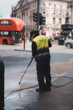 Westminster, Londra the 124; İngiltere - 2021.05.02: Kaldırımları yüksek basınçlı temizleyen adam