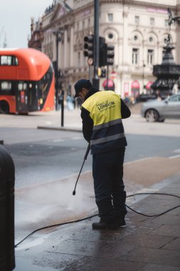 Westminster, Londra the 124; İngiltere - 2021.05.02: Kaldırımları yüksek basınçlı temizleyen adam