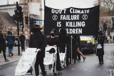 Westminster, London | UK -  2021.05.08: Extinction Rebellion activists marching slowly towards Downing Street with White Baby Prams clipart