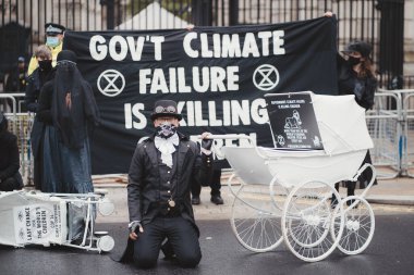 Westminster, London | UK -  2021.05.08: Extinction Rebellion activists kneeling in front of Downing Street with White Baby Prams clipart