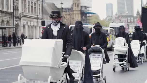 Utplåning Uppror aktivister marscherar långsamt mot Downing Street med vita baby Prams — Stockvideo