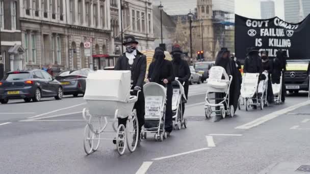 Activistas de la rebelión de extinción marchan lentamente hacia Downing Street con cochecitos de bebé blancos — Vídeo de stock