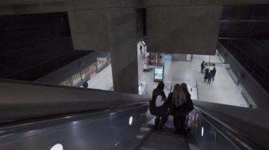 Canary Wharf metro istasyonundaki yürüyen merdivendeki insanlar.