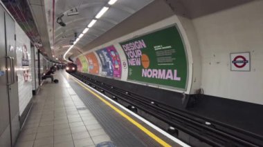 Tren, insanlar platformda beklerken Shepherd 's Bush istasyonuna geliyor.