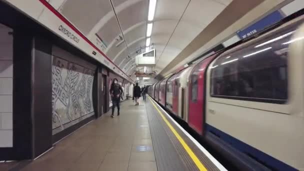 Trein die het Oxford Circus station verlaat terwijl mensen door het perron lopen — Stockvideo