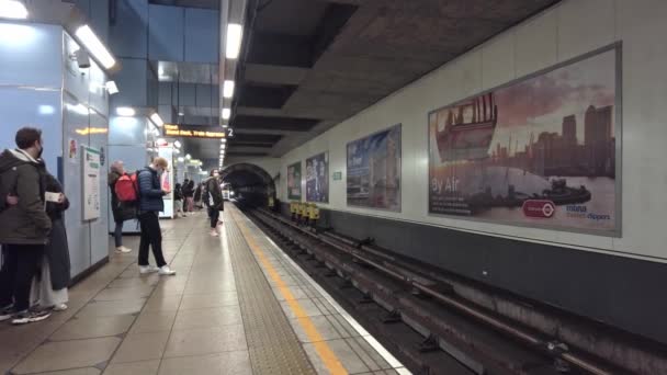 Ludzie czekają na pociąg na peronie stacji Cutty Sark DLR — Wideo stockowe